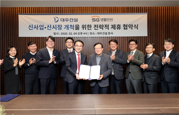김창환 대우건설 신사업본부장 전무(왼쪽에서 여섯 번째), 이상룡 SG생활안전 대표(왼쪽에서 다섯 번째)가 4일 을지로 대우건설 본사에서 전략적 사업제휴를 위한 양해각서를 체결하고 기념사진을 촬영하고 있다./대우건설
